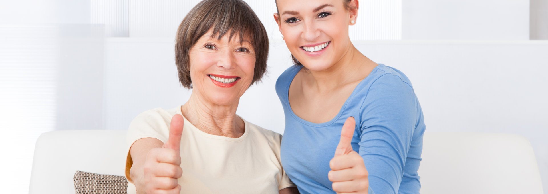 young woman and elderly woman thumbs up